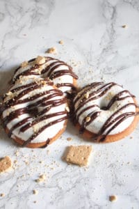 Graham cracker doughnuts topped with vanilla bean marshmallow fluff, drizzled with dark chocolate ganache topped with crushed graham crackers.